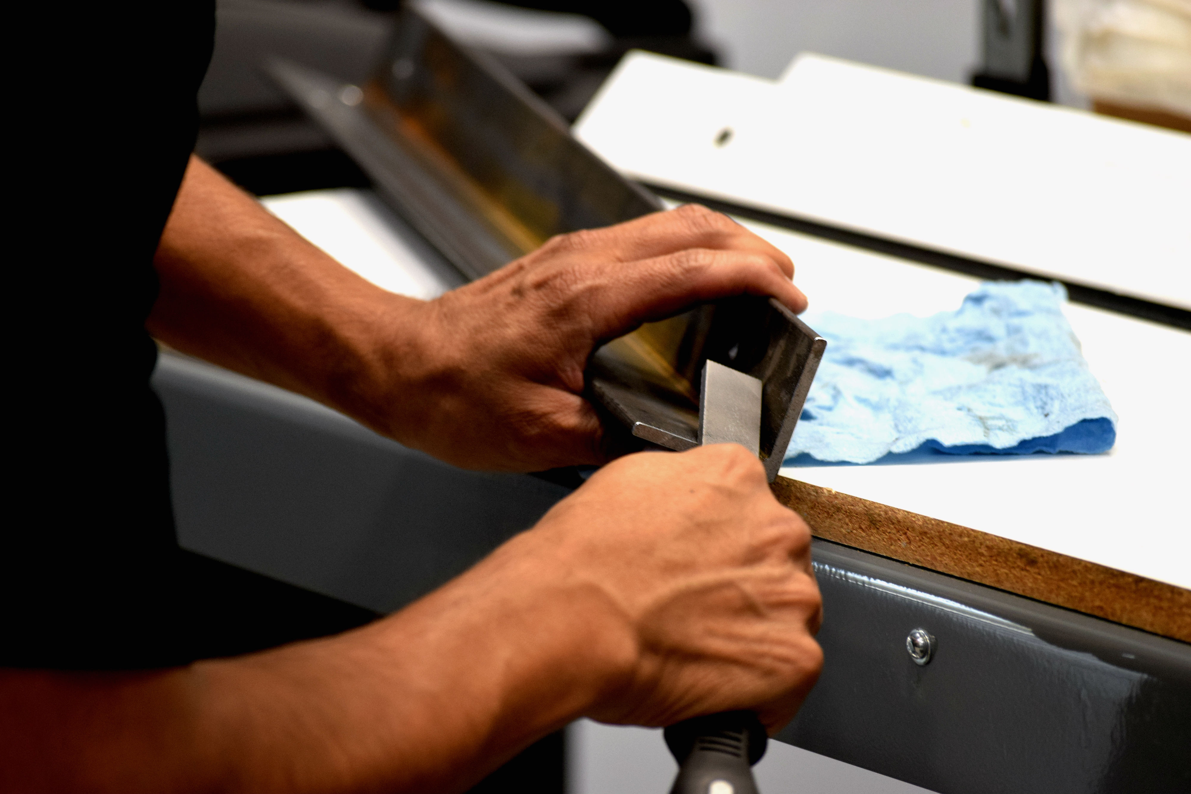 A person using a large metal chisel on paper.