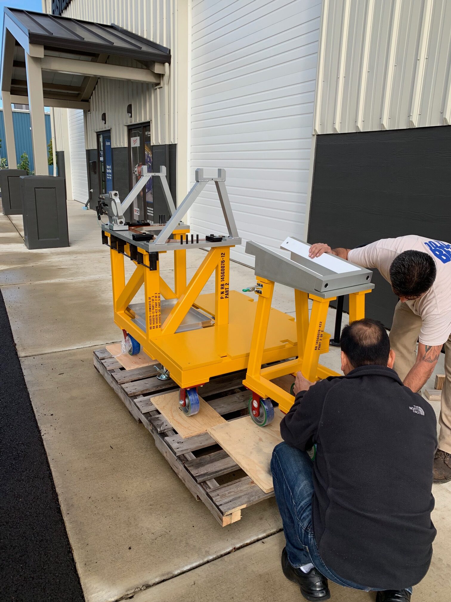 Two men working on a yellow machine.