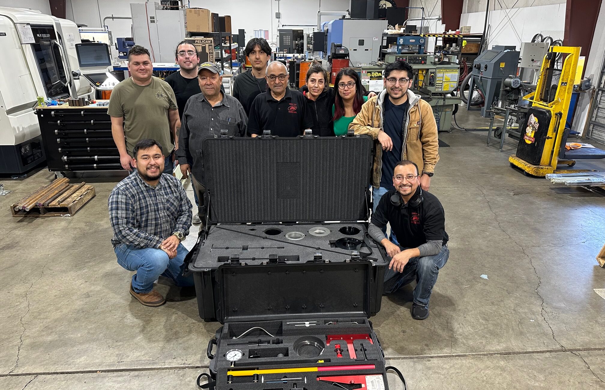 A group of people posing with equipment in front of them.